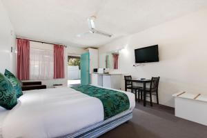 科夫斯港科夫斯港太平洋棕榈汽车旅馆的酒店客房配有一张床铺和一张桌子。