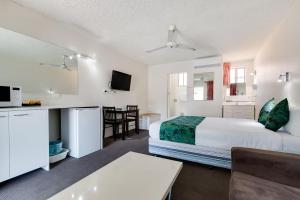 科夫斯港科夫斯港太平洋棕榈汽车旅馆的酒店客房设有一张床、一间厨房和一张桌子