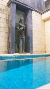库塔彭杜克米拉酒店的站在游泳池旁的女人雕像