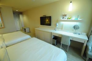 高雄康桥商旅 - 光荣码头的酒店客房配有一张床和一张带镜子的书桌