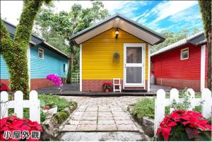员山乡枕山春海民宿的一座黄色和红色房子的小房子