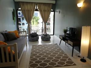瓜埠皮诺广场公寓的带沙发和电视的客厅以及带桌子的房间。