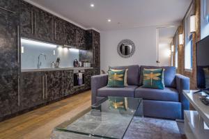 伦敦Soho One的客厅配有蓝色的沙发和玻璃桌