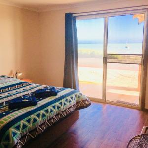 德纳姆海湾度假屋的一间卧室配有一张床,享有海景