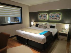 伊兹密尔伊兹密尔天宝居康福特酒店的一间卧室设有一张大床和一个窗户。