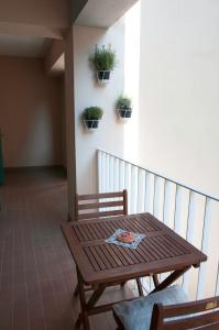 皮兰Spacious balcony apartment Piran的阳台上配有木桌和椅子,种植了盆栽植物