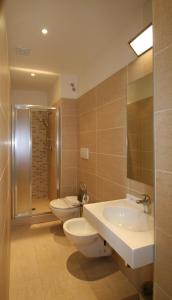 里米尼丽城海滩酒店的浴室设有2个卫生间、水槽和淋浴。