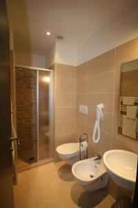 里米尼丽城海滩酒店的一间带两个盥洗盆、淋浴和卫生间的浴室