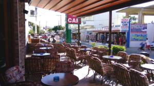 普拉坦斯卡泰里尼公寓酒店的一间空的咖啡馆,里面摆放着桌椅,街上