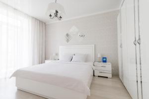 布雷斯特普希金城市生活公寓的白色卧室配有白色的床和白色橱柜