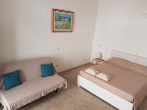 滨海波利尼亚诺La Maison A La Mer的一间卧室配有一张床和一张沙发