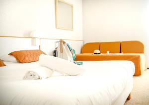 维希Hôtel des Thermes Les Dômes的酒店客房,设有两张床和一张沙发