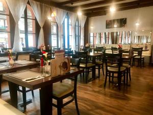 因特拉肯托斯卡纳酒店的餐厅设有木桌、椅子和窗户。
