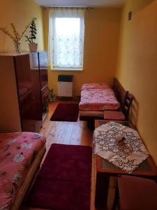 LiskováPrivat DAŇO的客房设有两张床、一张桌子和一扇窗户。
