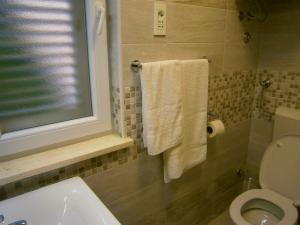 科米扎Room Vilma的一间带卫生间、窗户和毛巾的浴室
