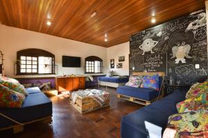 格拉玛多Hostel Chocolatchê的客厅配有蓝色的沙发和黑板