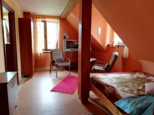GiżeAgroturystyka Giże的一间卧室拥有橙色的墙壁和一张床及椅子