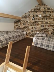 斯帕L'Atelier的一间设有两张床和砖墙的房间