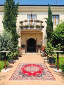 纳托Agriturismo Mulino Bianco的建筑前方的庭院,有红色地毯