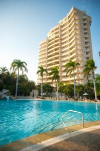 圣玛尔塔Irotama Resort Zona Torres的棕榈树和游泳池的大型酒店