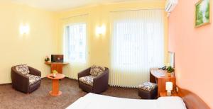 瓦尔纳Family Hotel Varna的酒店客房带椅子、一张床和电视