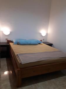 马塔兰普济民宿的一间卧室配有一张带蓝色枕头的床和两盏灯。