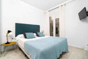 瓦伦西亚Flatsforyou Ruzafa的一间卧室配有一张带蓝色毯子的大床