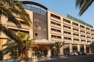 维辛达里奥厄尔巴维辛达里奥机场商务及会议酒店的一座棕榈树环绕的大建筑