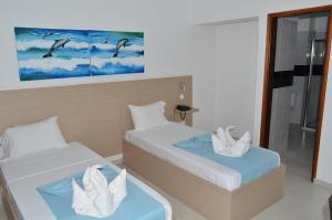 普拉亚瑟萨瑞阿酒店的客房设有两张床和玻璃淋浴间。