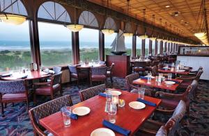 洋滨市大西洋海岸希洛套房酒店的餐厅设有桌椅和窗户。