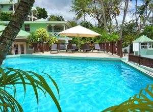 马里戈特湾马里戈海滩俱乐部潜水度假酒店的一个带椅子和遮阳伞的大型蓝色游泳池