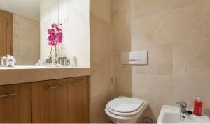里斯本My Oriente的浴室设有卫生间和粉红色鲜花水槽。