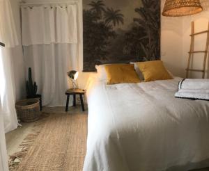 巴斯蒂亚Appartement Casalea - Casadibastia - Bastia centre的一间卧室配有带白色床单和黄色枕头的床。
