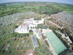 Santa LuciaMasseria Guadiano Vecchio的网球场和建筑物的空中景致