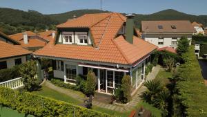 阿尔戈尼奥斯Chalet Argoños的一座带橙色屋顶的大房子