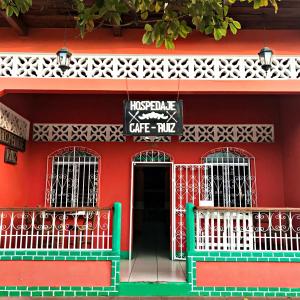 格拉纳达Hospedaje y Cafe Ruiz的红色的建筑,上面有在咖啡馆里读书的标志