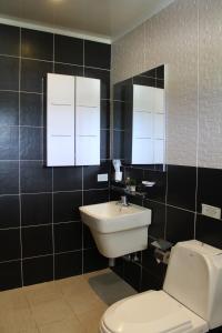 塞班获奖者住宅酒店的浴室配有白色卫生间和盥洗盆。