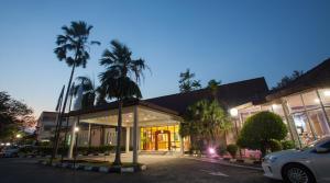 瓜拉弄宾赛里马来西亚龙平酒店的棕榈树建筑前的停车场