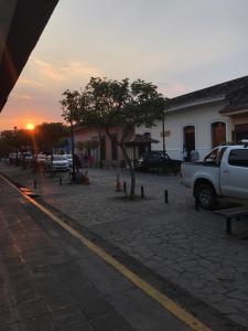格拉纳达Hospedaje y Cafe Ruiz的一辆停在街道上的卡车,背着日落