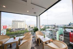 胡志明市西贡酒店的餐厅设有桌椅和大窗户。