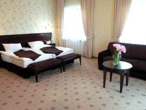 Okuniew薇拉扎古酒店的一间卧室配有一张床、一张沙发和一张桌子