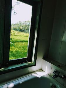 乌布英昂旅馆的浴室水槽设有可欣赏田野景致的窗户