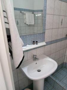 托隆金月旅馆的浴室设有白色水槽和镜子
