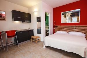 奥尔贝泰洛Hotel La Posta di Torrenova的一间带白色床的卧室和一间厨房