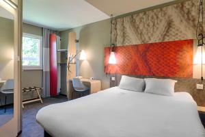 蒙托邦蒙托邦宜必思酒店的酒店客房设有一张大床和一张书桌。