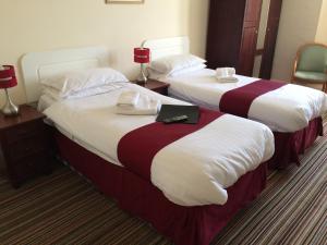 滨海韦斯顿New Birchfield Hotel的酒店的客房内设有两张床,配有笔记本电脑。