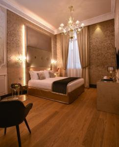 威尼斯圣克罗斯精品酒店的一间卧室配有一张大床和一个吊灯。
