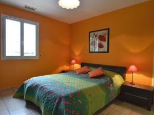 博默德弗尼瑟Luxury villa with garden and covered terrace的一间卧室配有一张带橙色墙壁的床和2个窗户。