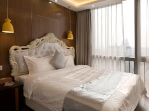 广州铂满度假公寓北京路捷登都会店的卧室配有白色的床和大窗户