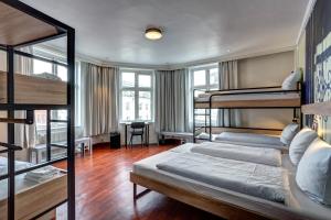 哥本哈根哥本哈根城市之家梅宁阁酒店的客房设有两张双层床和一张书桌。